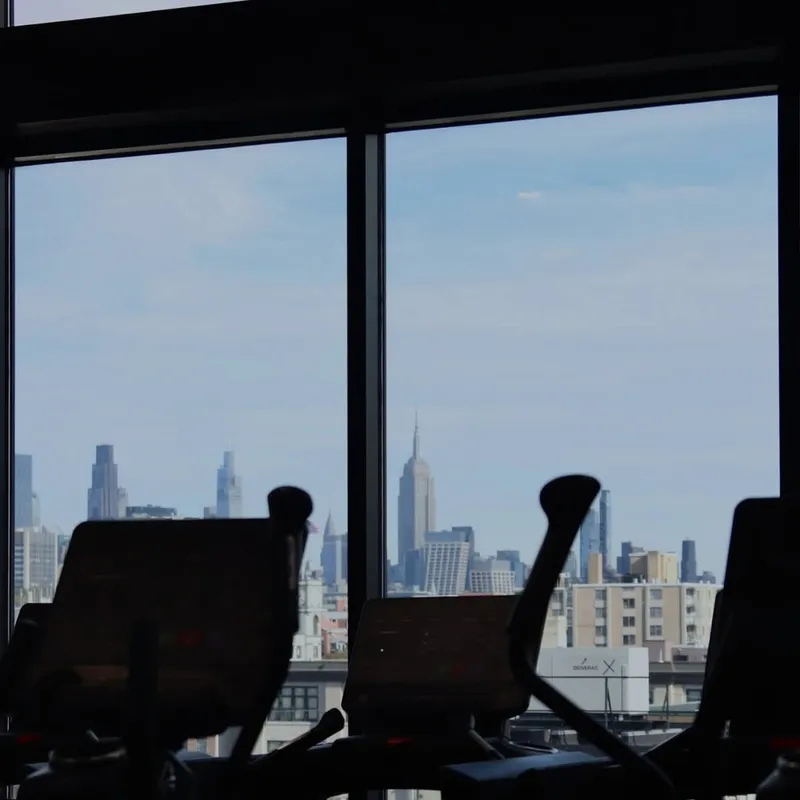 Treadmills facing the Manhattan skyline at XCEL Athletic Lifestyle, a rooftop gym in Hoboken, NJ