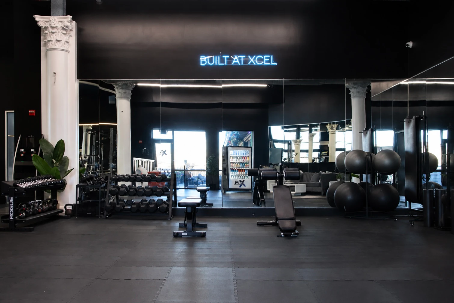 Built at XCEL training studio with dumbbells and benches under the neon sign at XCEL Athletic Lifestyle, a rooftop gym in Hoboken, NJ