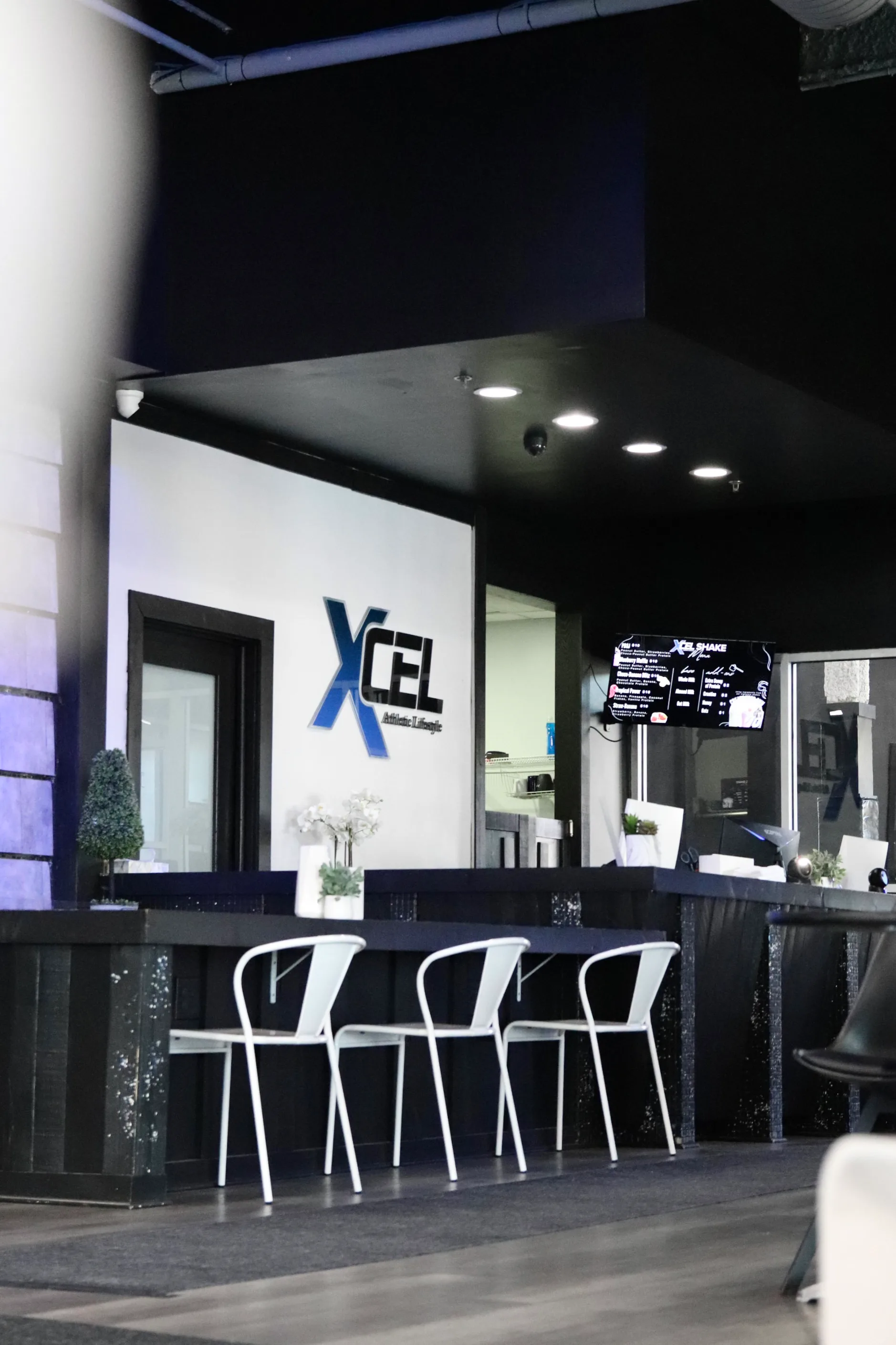 Front desk check-in counter with the XCEL logo at XCEL Athletic Lifestyle, a rooftop gym in Hoboken, NJ