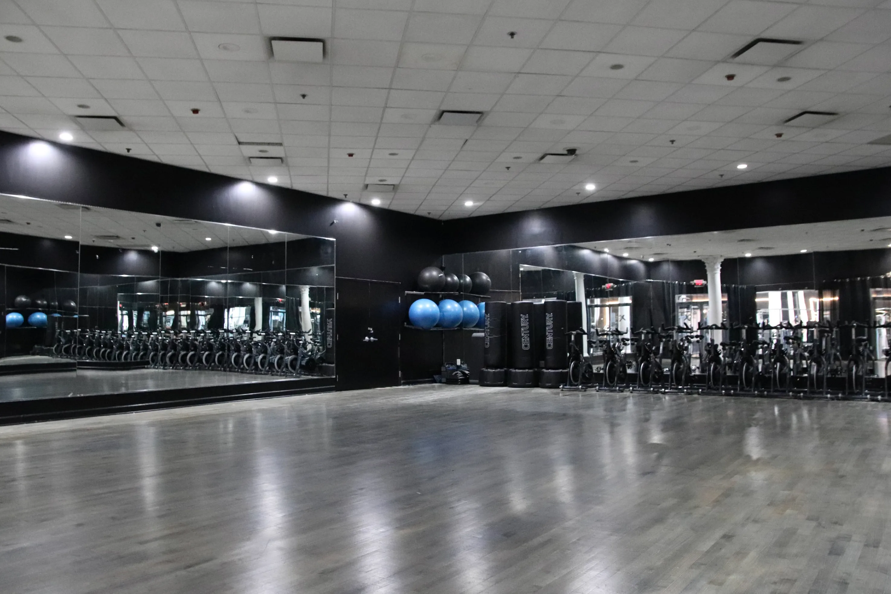 Group fitness studio with mirrors and hardwood floor at XCEL Athletic Lifestyle, a rooftop gym in Hoboken, NJ