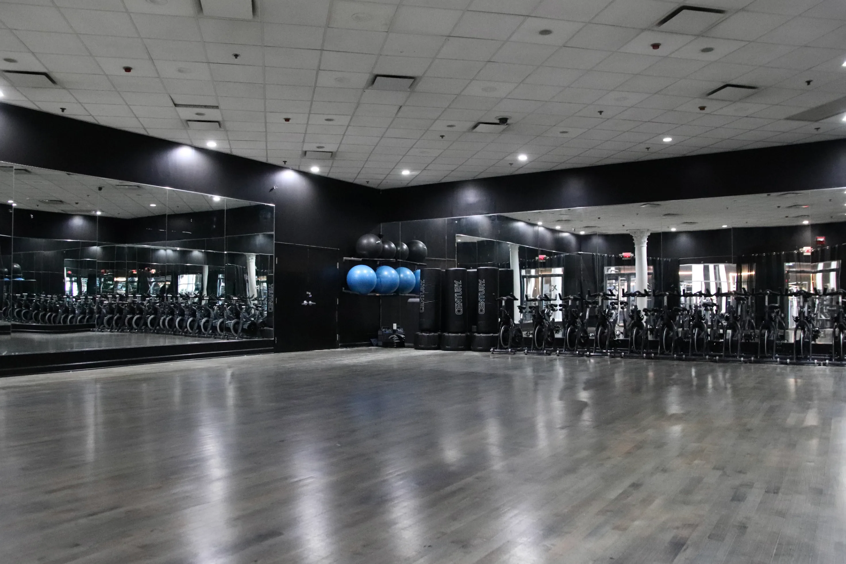 Group fitness studio with mirrors and hardwood floor at XCEL Athletic Lifestyle, a rooftop gym in Hoboken, NJ