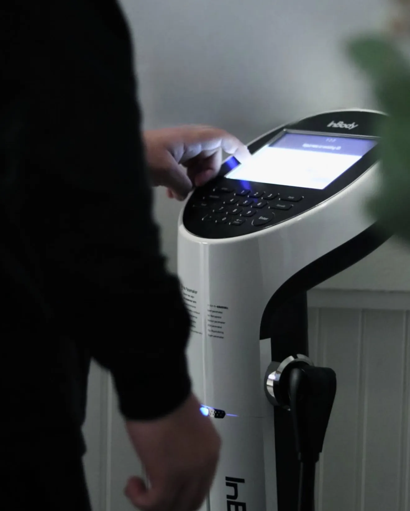 Hand placed on the InBody 570 body composition analyzer at XCEL Athletic Lifestyle, a rooftop gym in Hoboken, NJ